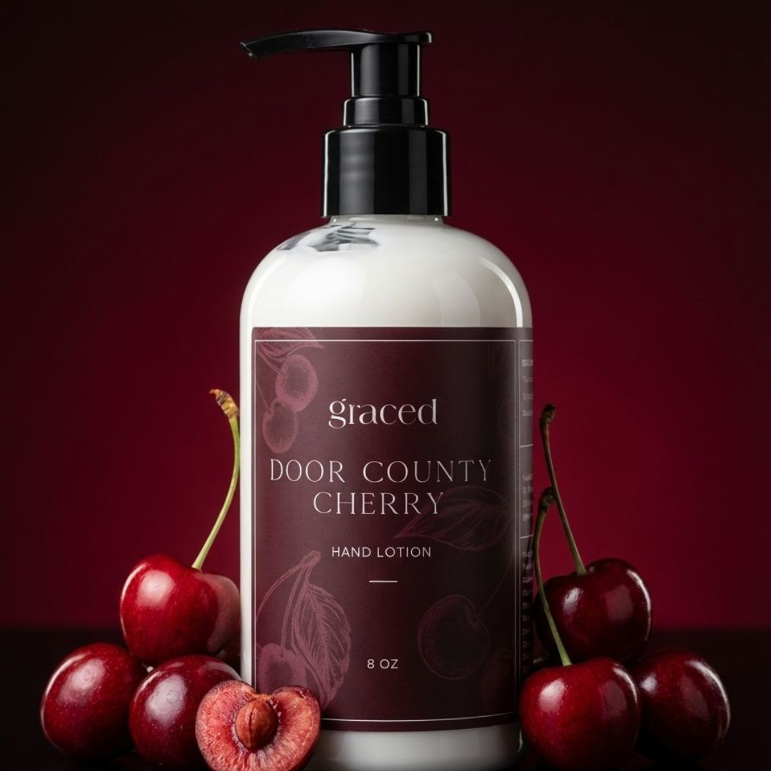 Hand lotion bottle labeled 'Door County Cherry' with cherries on a dark background