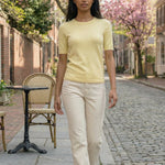 Woman walking on a street with cherry blossom trees in the background