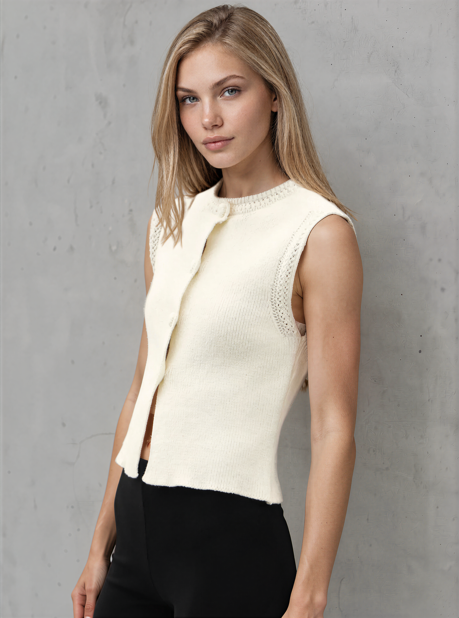 Woman wearing a cream sleeveless top against a gray background