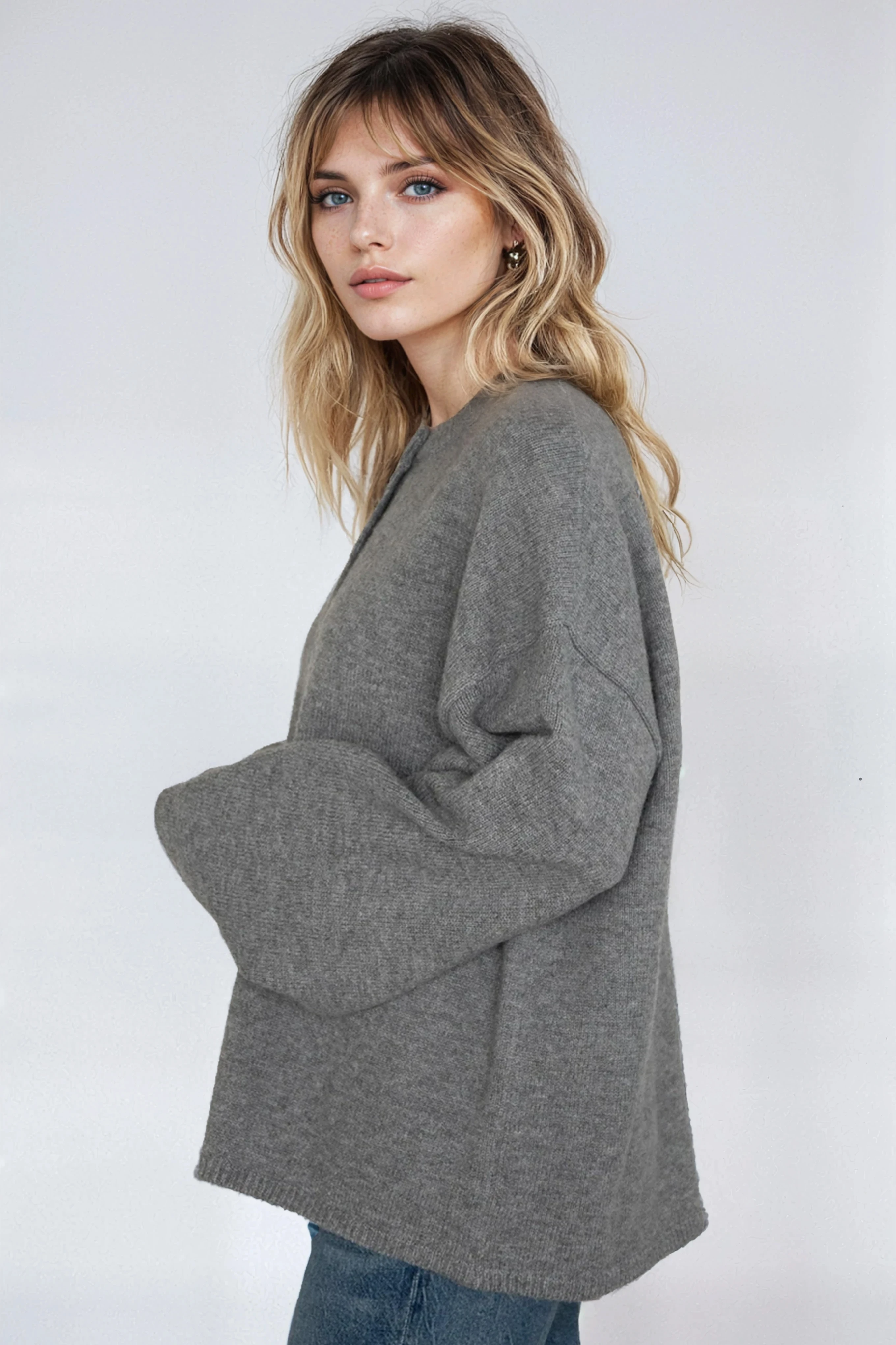 Woman wearing a gray sweater against a white background
