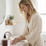 Woman washing hands with soap in a bathroom