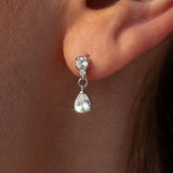 Silver teardrop earring worn on an ear