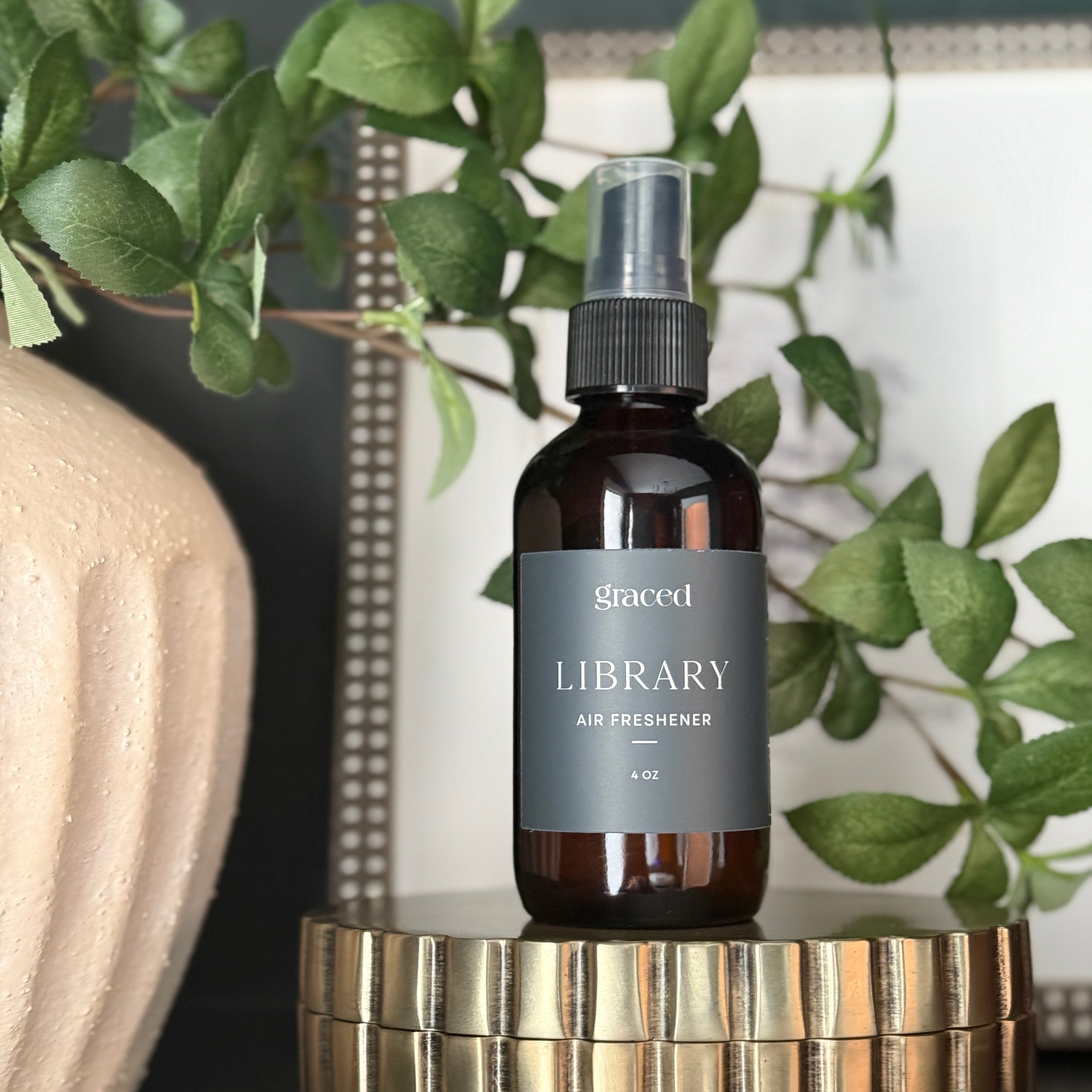 Bottle of 'Library' air freshener on a decorative stand with greenery in the background