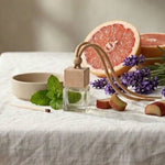 Table setting with a bowl, glass, and grapefruit on a white tablecloth against a neutral wall.