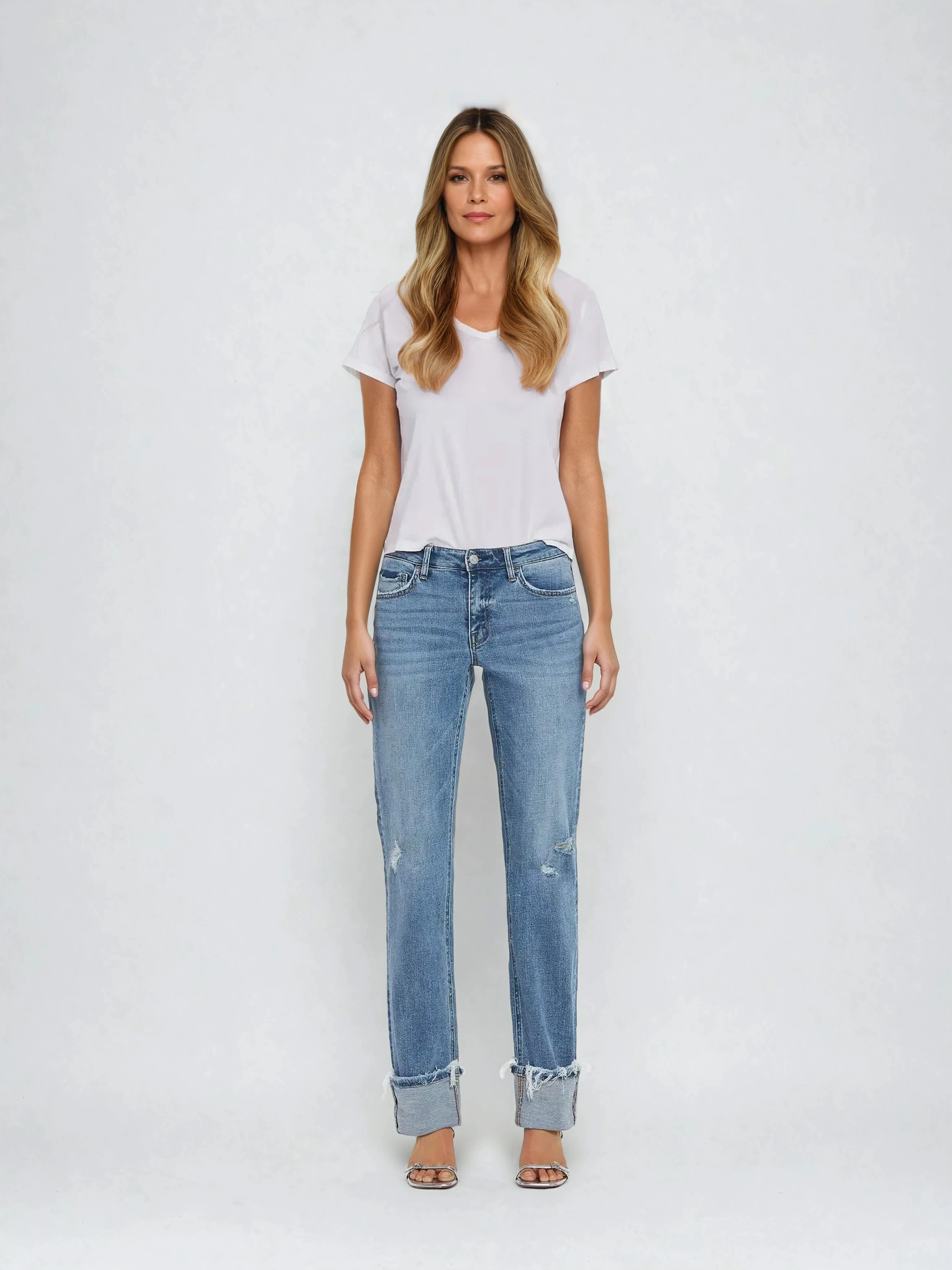 Woman wearing a white t-shirt and blue jeans on a white background
