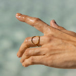 Hand with a ring on a blurred natural background