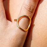 Gold ring on a person's finger with a close-up view of the skin.