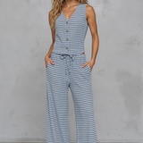 Woman wearing a blue and white striped jumpsuit against a gray background