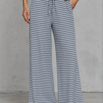 Person wearing blue and white striped wide-leg pants against a gray background
