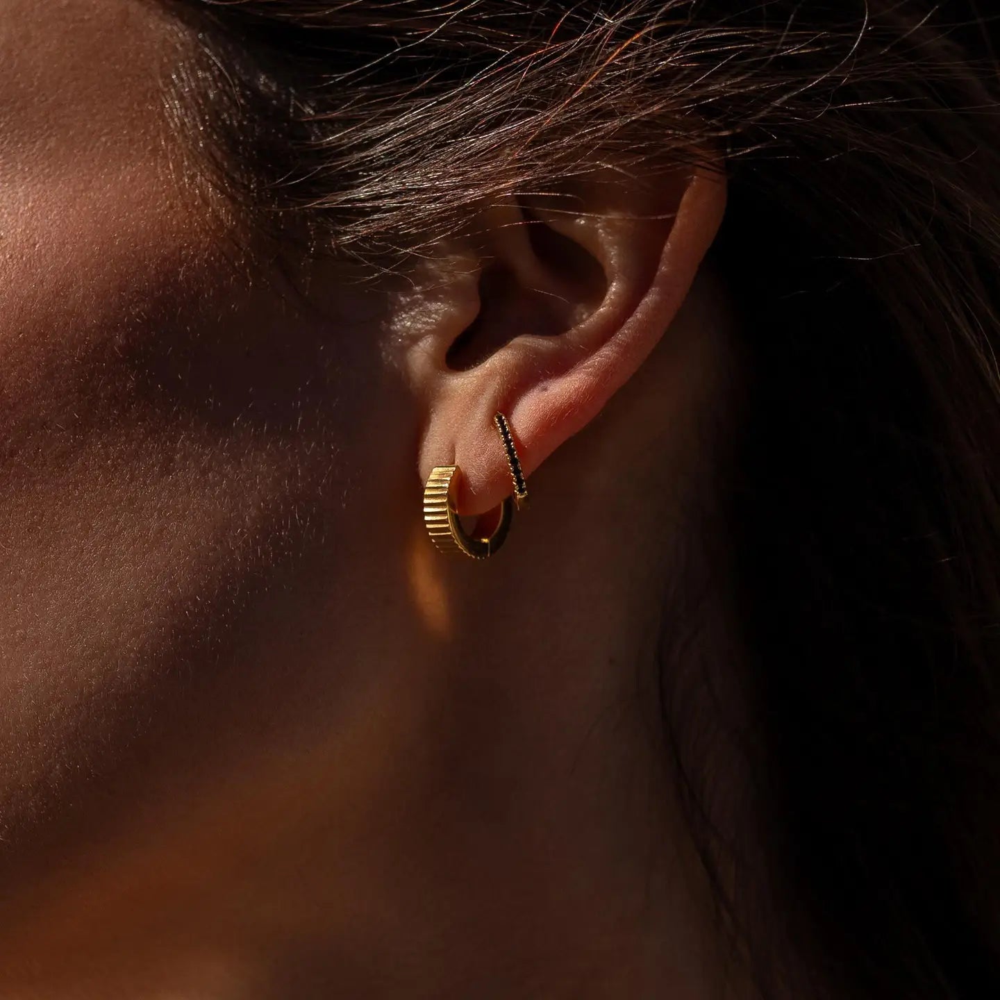 Gold Roman Huggies earrings by ALCO, small hoop jewelry accessory with a classic Roman-inspired design.