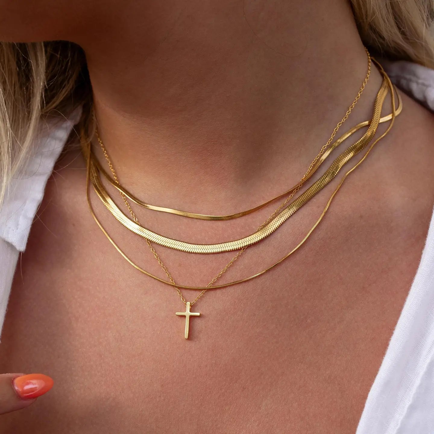 Gold cross necklace by ALCO featuring a sleek design, perfect as a jewelry accessory for everyday or special occasions.