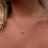 Gold ALCO cross necklace, a jewelry accessory with a sleek gold pendant on a delicate chain.
