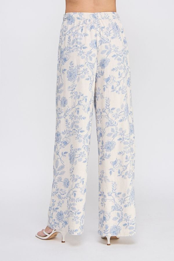 Allie Rose floral linen pants with a relaxed fit and vibrant floral pattern, styled as casual bottoms.