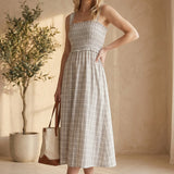 Blue plaid print smocked midi dress by Allie Rose featuring a fitted bodice and flowy skirt, suitable for casual or semi-formal wear.