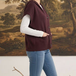 graced burgundy button down sleeveless hoodie worn by a woman with jeans and a white long sleeve top