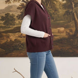 graced burgundy button down sleeveless hoodie worn by a woman with jeans and a white long sleeve top