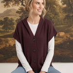 graced burgundy button down hoodie vest worn by a smiling woman over a white long sleeve shirt and blue jeans