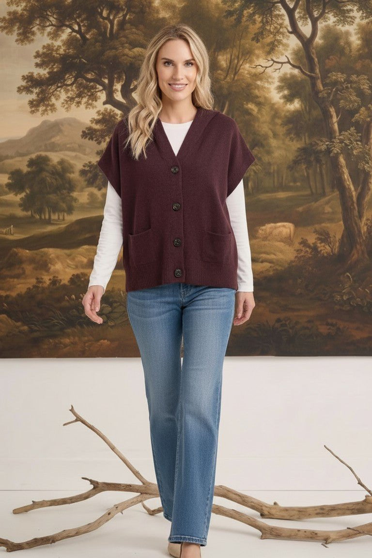 graced burgundy button down sleeveless hoodie layered over a white long sleeve top and blue jeans