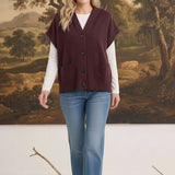 graced burgundy button down sleeveless hoodie layered over a white long sleeve top and blue jeans