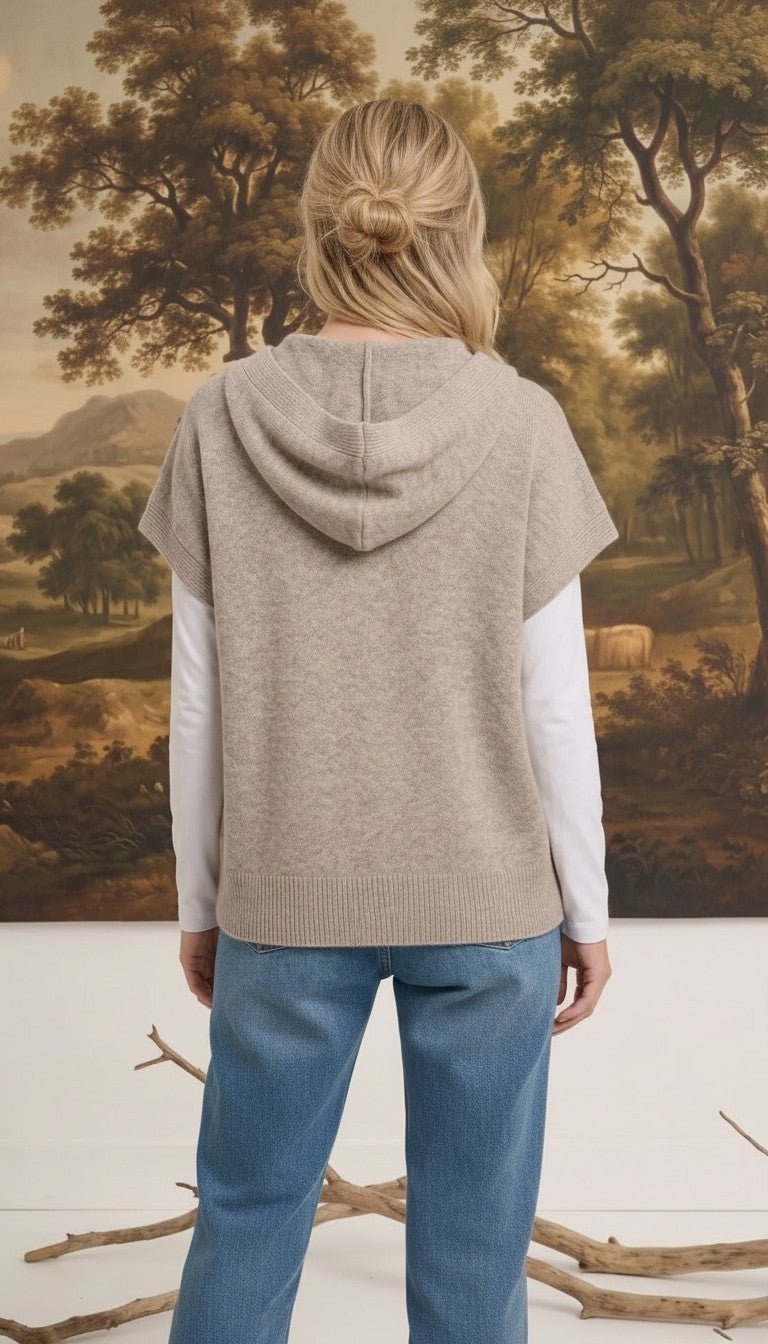 graced taupe button down hoodie top worn over a white long sleeve shirt with blue jeans, back view