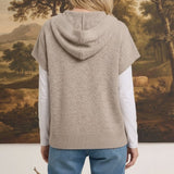 graced taupe button down hoodie top worn over a white long sleeve shirt with blue jeans, back view