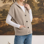 graced taupe button-down hooded vest worn by a woman over a white long-sleeve shirt and blue jeans