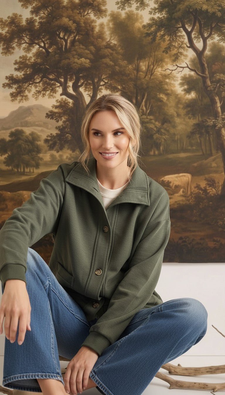 A woman wearing a graced olive mock neck button-down cardigan with a relaxed fit, styled with blue denim jeans.