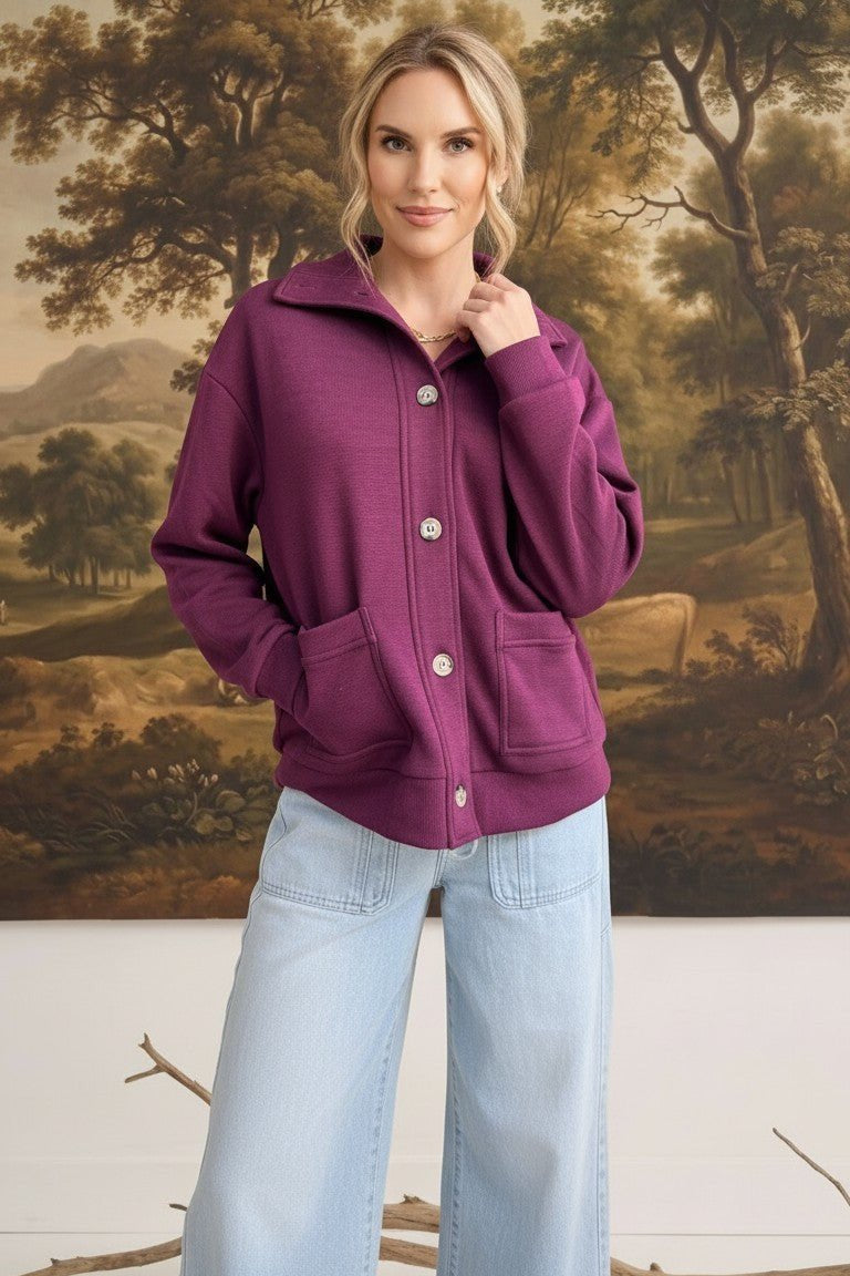 graced wine mock neck button down cardigan with front pockets worn by a model with light blue wide leg jeans