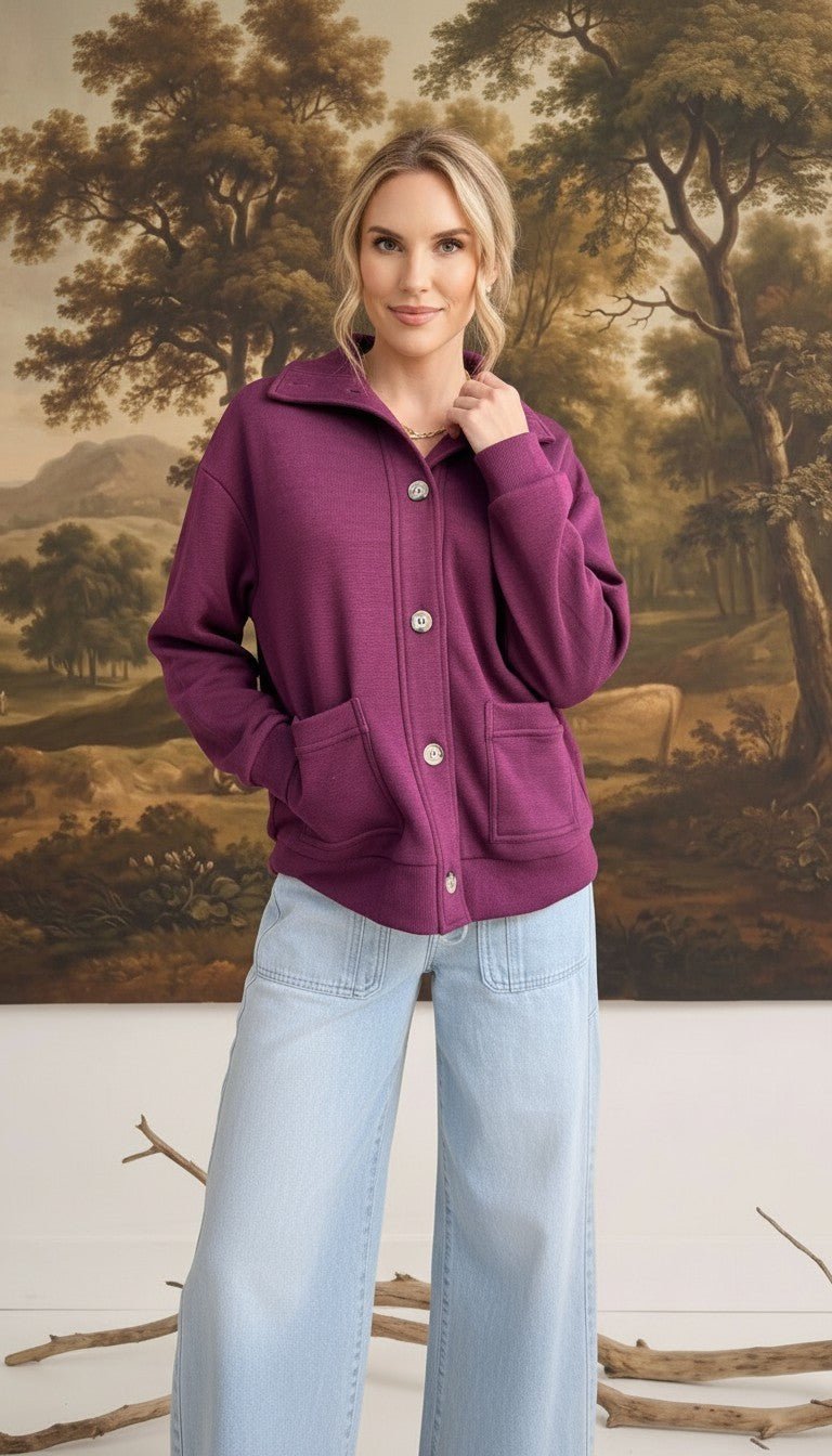 graced wine mock neck button down cardigan with front pockets worn by a model with light blue wide leg jeans