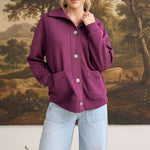 graced wine mock neck button down cardigan with front pockets worn by a model with light blue wide leg jeans