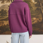 Back view of a woman wearing a wine-coloured graced mock neck cardigan with a relaxed fit and button-down detail.