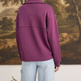 Back view of a woman wearing a wine-coloured graced mock neck cardigan with a relaxed fit and button-down detail.