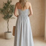 Blue and white striped strapless maxi dress with a smocked bodice by By Together, featuring a flowing silhouette and vibrant pattern.