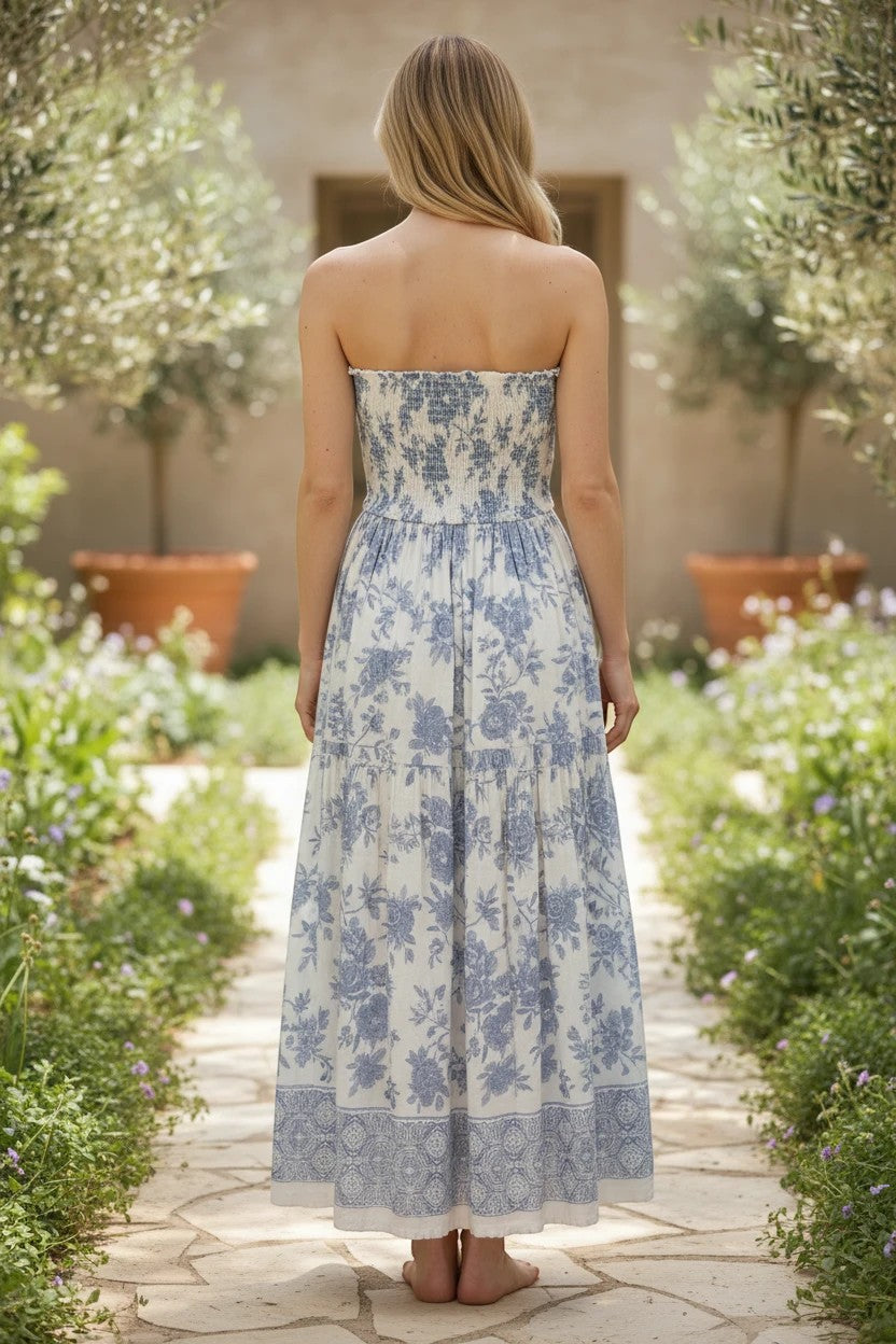 Blue and white floral smocked strapless midi dress by By Together, featuring a fitted bodice and flowing cotton-rayon fabric.