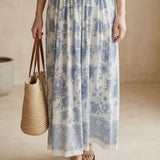 Blue and white floral smocked strapless midi dress by By Together, featuring a flowy cotton-rayon fabric and a fitted bodice.