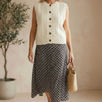Be Cool cable knit sweater vest, cream-colored knit top with ribbed edges and a classic cable pattern displayed on a neutral background.