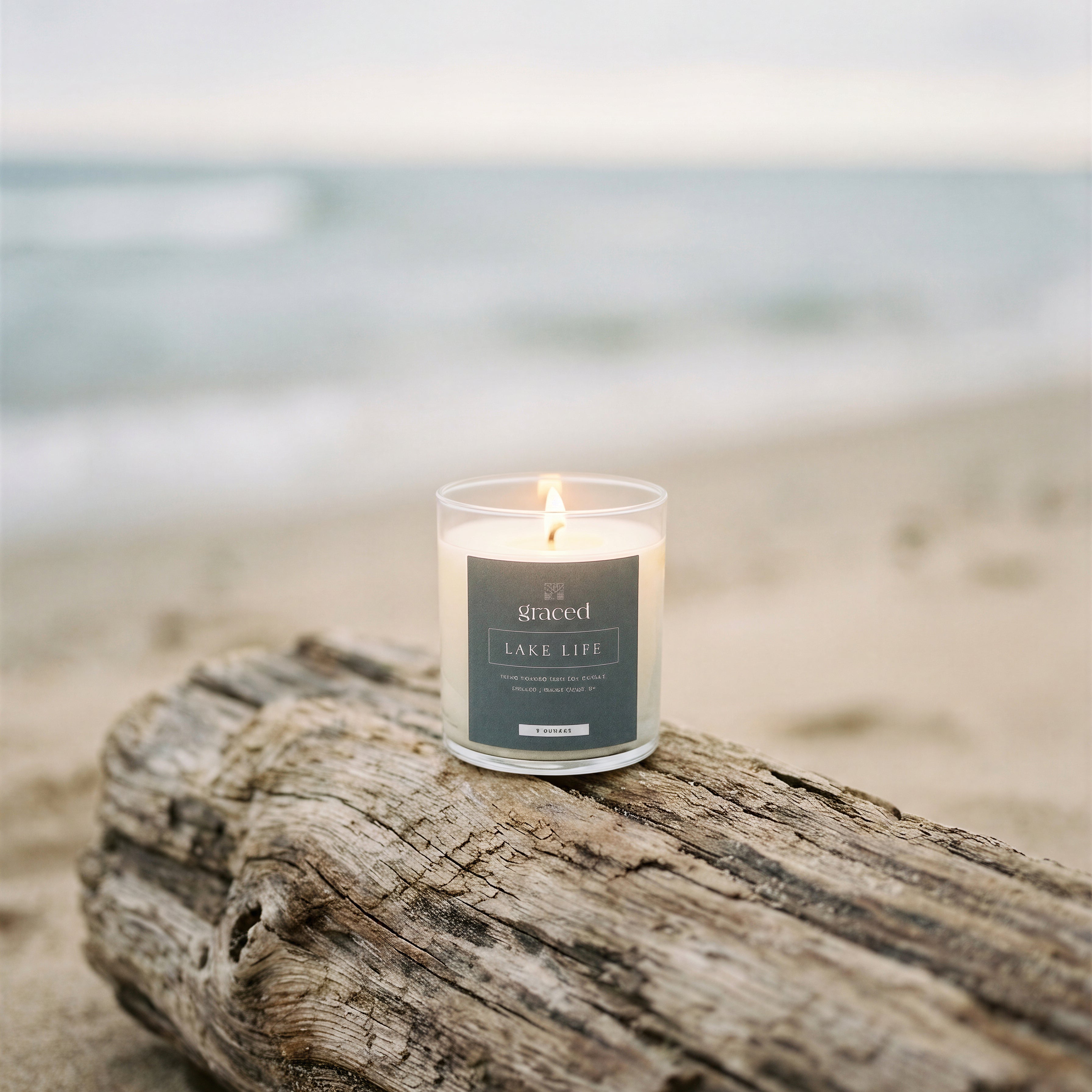 Candle on a piece of driftwood with a beach background