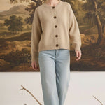 graced mushroom crew neck cardigan with button front, worn by a model with light blue jeans in a studio setting