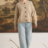graced mushroom crew neck cardigan with button front, worn by a model with light blue jeans in a studio setting