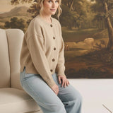 Model wearing a graced mushroom crew neck cardigan with brown buttons, paired with light wash jeans in a studio.