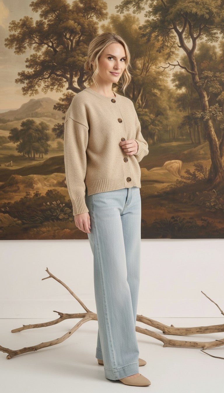 Model wearing a graced mushroom crew neck cardigan with button front and relaxed fit paired with light wash jeans