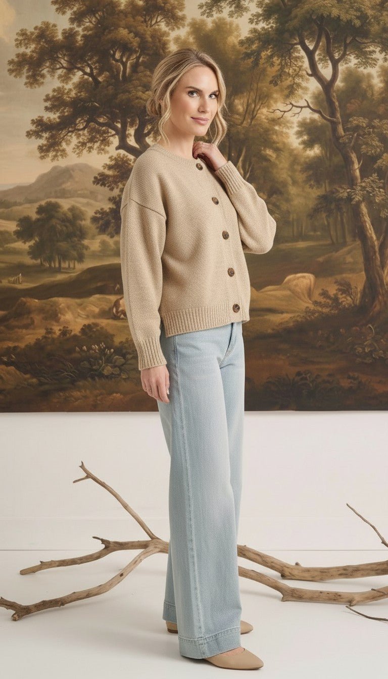 Model wearing a graced mushroom crew neck cardigan with button front and relaxed fit paired with light wash jeans