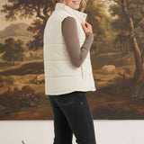 graced cream corduroy puffer vest worn by a woman over a brown long-sleeve top and black jeans