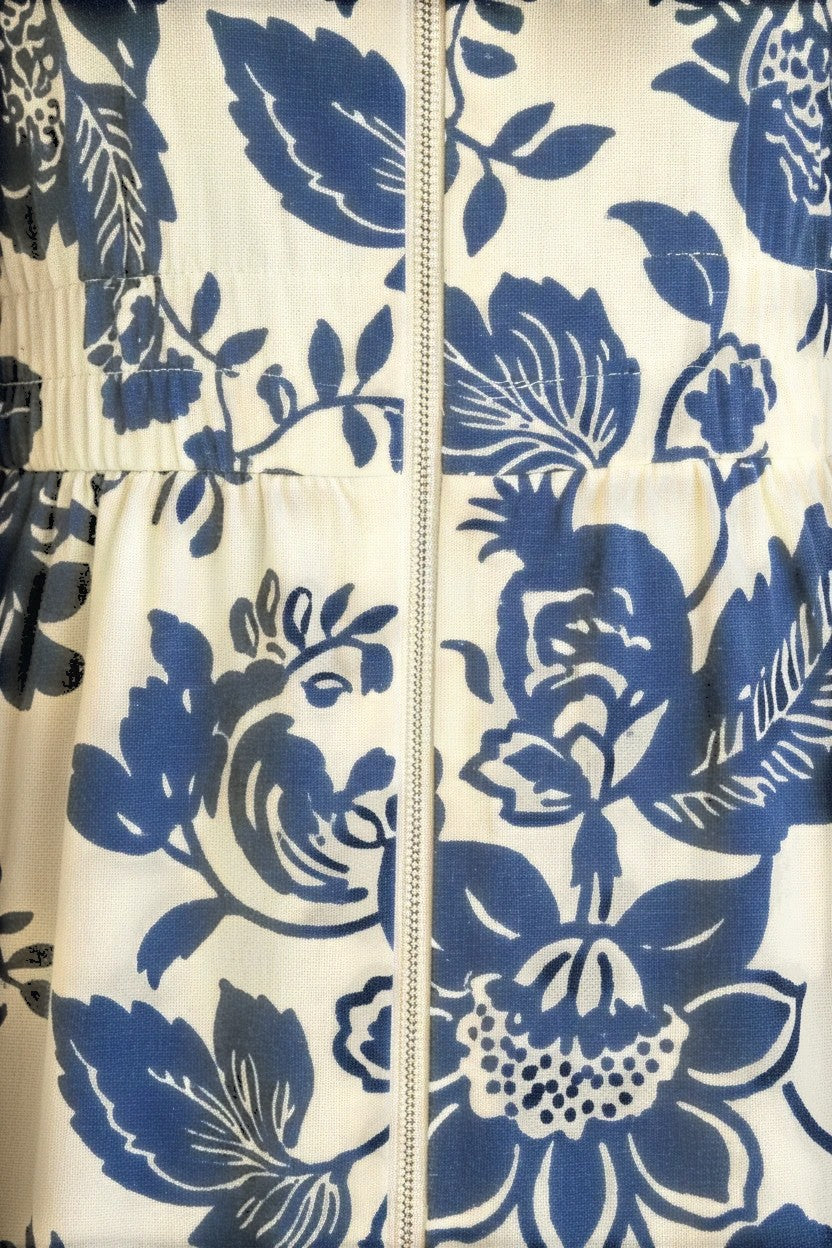 Blue floral V-neck smocked waist midi dress by Doe and Rae, shown on a model with flowing fabric and a stylish silhouette.