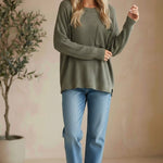 Model wearing a graced forest green dolman long sleeve knit sweater with a chest pocket and relaxed fit.