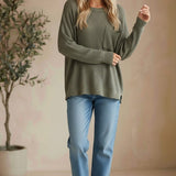 Model wearing a graced forest green dolman long sleeve knit sweater with a chest pocket and relaxed fit.