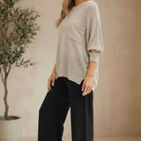 Model wearing a graced pebble dolman long sleeve knit sweater with a chest pocket and relaxed fit.