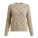 graced beige crewneck sweater featuring a black polka dot knit pattern and ribbed cuffs in a classic fit.