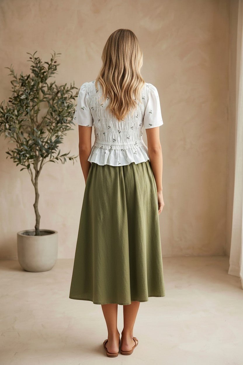 Embroidered peplum blouse by Camellia featuring pleated design, intricate embroidery, and elegant long sleeves.
