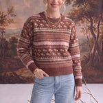 Model wearing a graced mocha Fair Isle knit sweater with floral and geometric patterns, styled with light wash jeans.